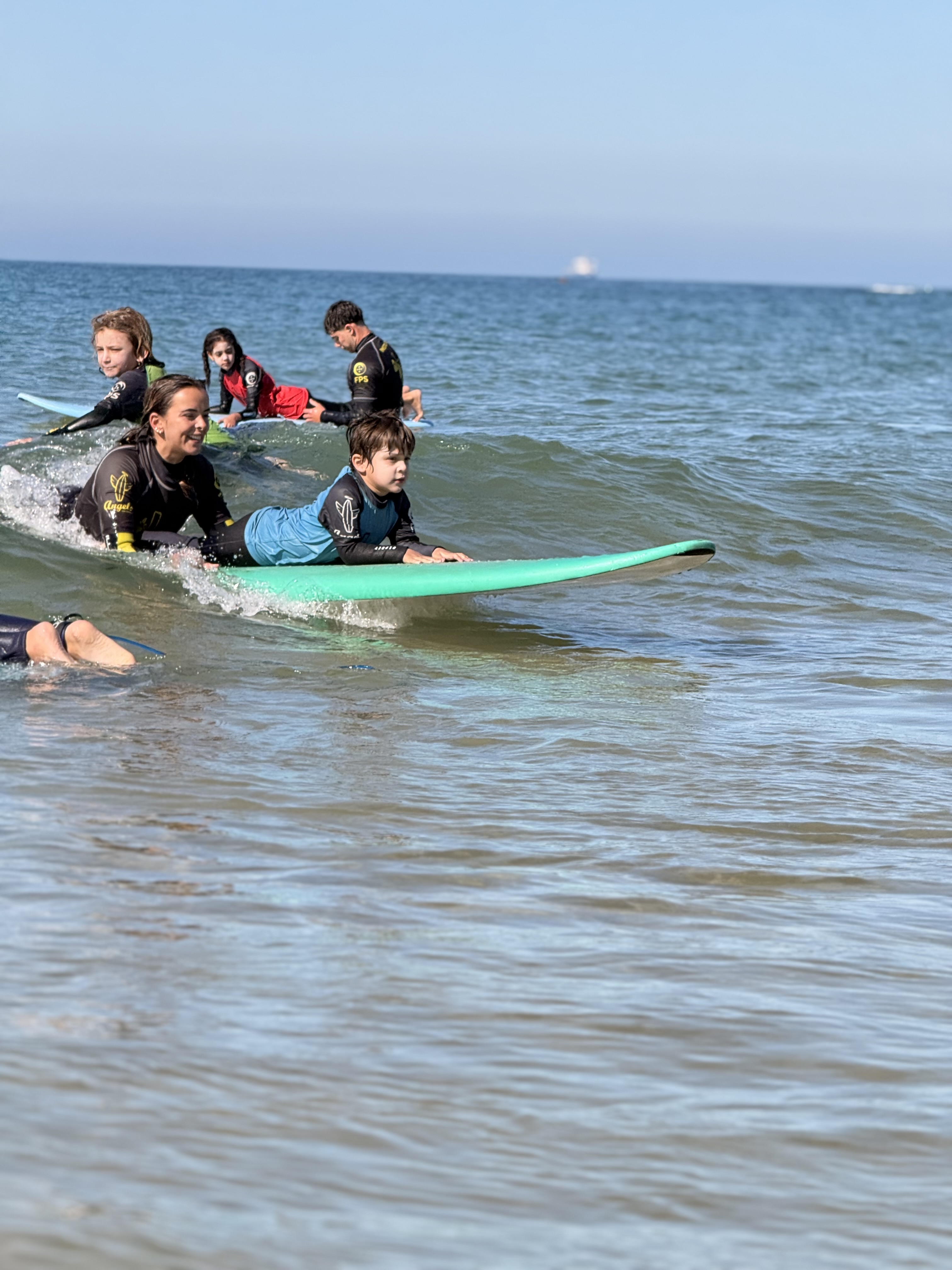 Bia sorrindo durante aula de surf