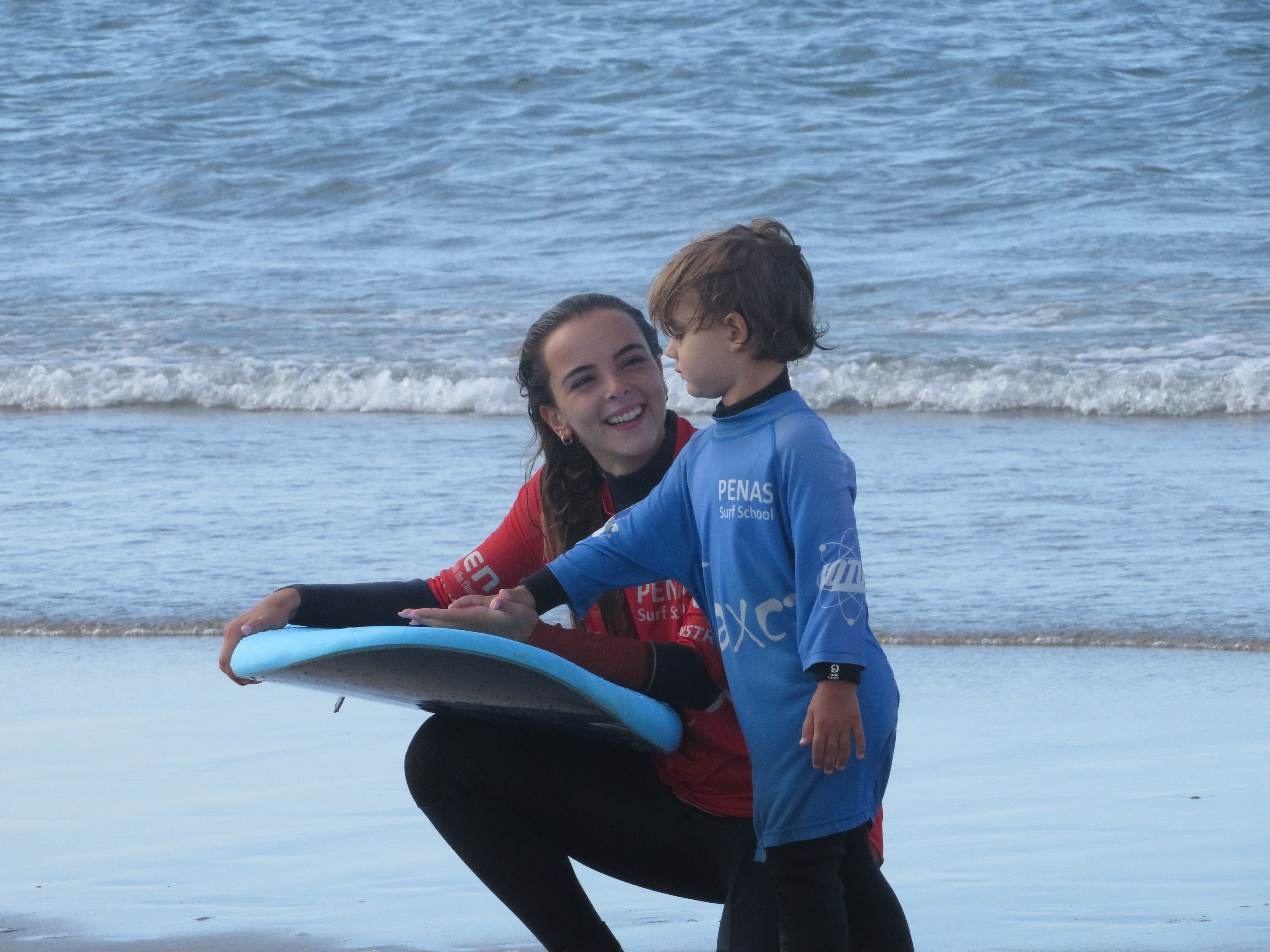 Bia com criança na escola de surf Penas — retrato íntimo